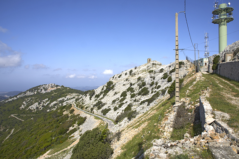 chemin d'accès et alignement de la moitié gauche, haute, du front de gorge de l'enceinte et antenne-relai, à l'arrière plan, l'ouvrage ouest