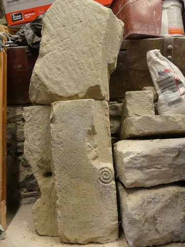 Eléments lapidaires démontés (claveau chanfreiné et départ de jambage avec congé en spirale) de l'arcade anciennement située sous le passage couvert (élévation ouest).