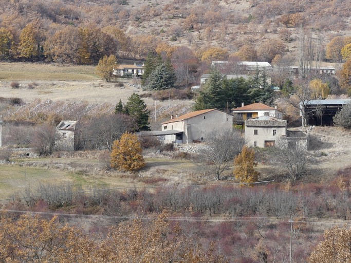 Vue d'ensemble d'une ferme au quartier de l'Adrech (Ribiers) : bâtiment principal avec cour fermée, dépendances disjointes (dont un colombier), maison disjointe et grands hangars ajoutés pendant la seconde moitié du 20e siècle.