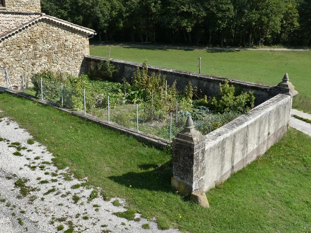 Cour. Mur de clôture et jardin installé à l'angle sud-est.