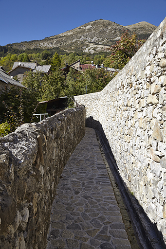 Le ravin du Riou canalisé longe des jardins et vergers enclos (à droite) et ménage une promenade à pied sec à côté du canal d'irrigation.