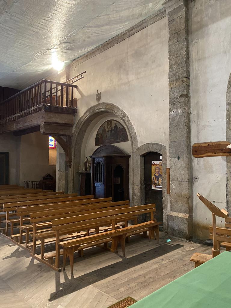 Vue de l'arcade de la chapelle orientale obturée et de la porte du clocher.