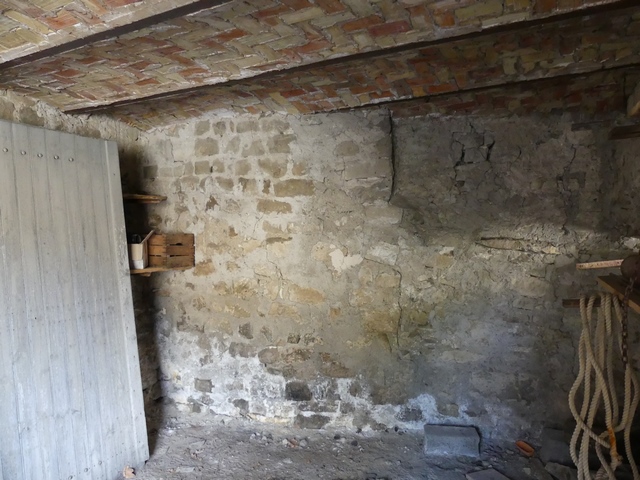 Rez-de-chaussée, remise. Mur sud, vestiges de la tour ronde.