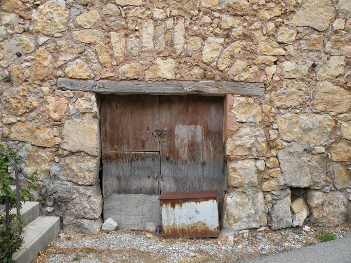 Le Touron, porte de remise avec linteau en bois et arc de décharge (B2 595).