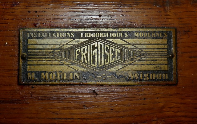Rez-de-chaussée surélevé, boucherie. Mur sud, porte de la grande chambre froide. Plaque du fabricant.