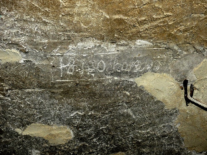 Rez-de-chaussée, étable nord. Inscription et date (1840) gravées dans l'enduit de la voûte.
