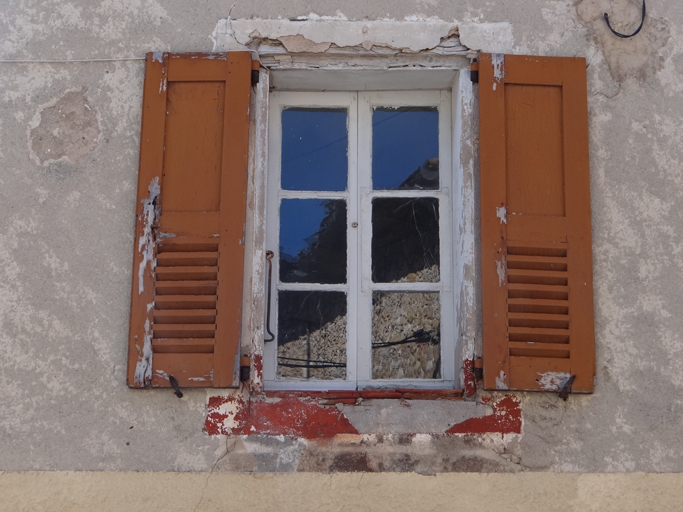 Fenêtre avec faux encadrement peint, équipée de contrevents à persienne basse. (C1 169)