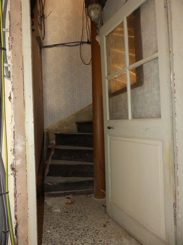 Rez-de-chaussée surélevé, départ de l'escalier menant à l'étage.