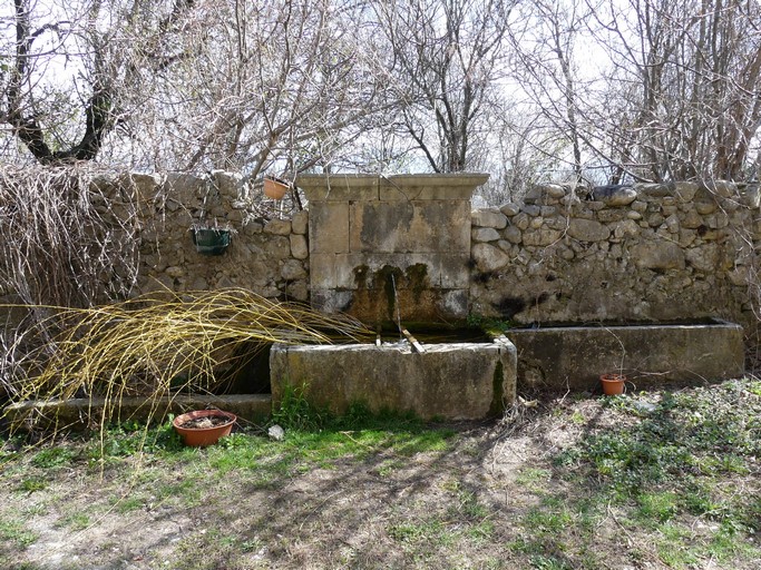 Fontaine et abreuvoir intégrés au mur du jardin.