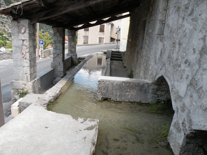 Entrevaux. Lavoir du Moulin. Le toit en appentis est soutenu par trois poteaux maçonnés.