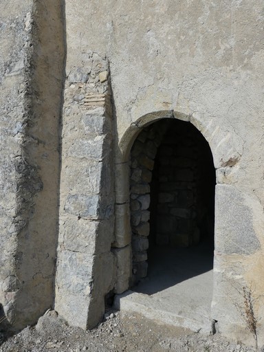 Porte d'étable avec encadrement en arc plein-cintre chanfreiné et piédroits à quart-de-rond ; contreforts talutés. Bâtiment au quartier de Saint-Aubert (Ribiers).