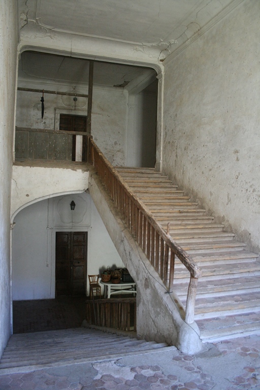 Escalier tournant central à retour rampe-sur-rampe depuis le palier intermédiaire menant au deuxième étage carré.