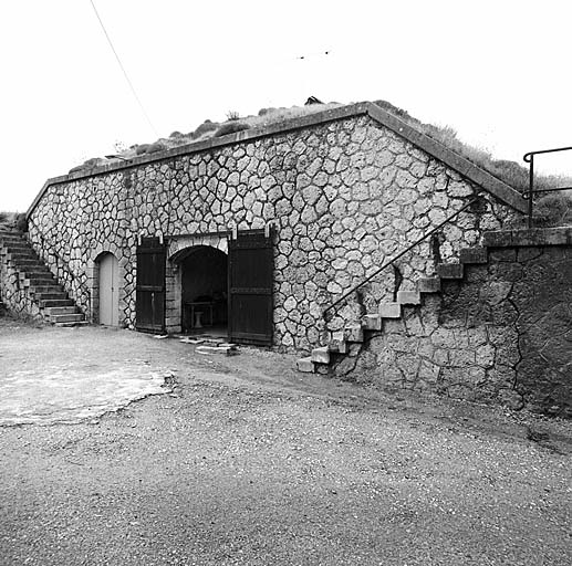 Front de tête. Vue intérieure. Façade de l'abri 5. A gauche, porte d'accès au poste optique g. A droite, porte de l'abri et escalier d'accès à la plateforme 7