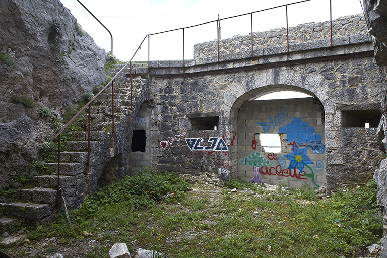 ancienne porte de l'ouvrage encadrée de créneaux, vue de la courette encaissée