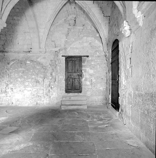 Cloître. Détail : travée d'angle sud-ouest, mur sud : porte d'accès à l'étage et baies murées.