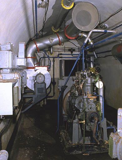 Centrale électrique (usine). Vue intérieure. A gauche, tableau électrique et ventilateur avec batterie de chauffe. Au centre, groupe SMIM à cylindres. A droite, réservoir journalier à gazole.