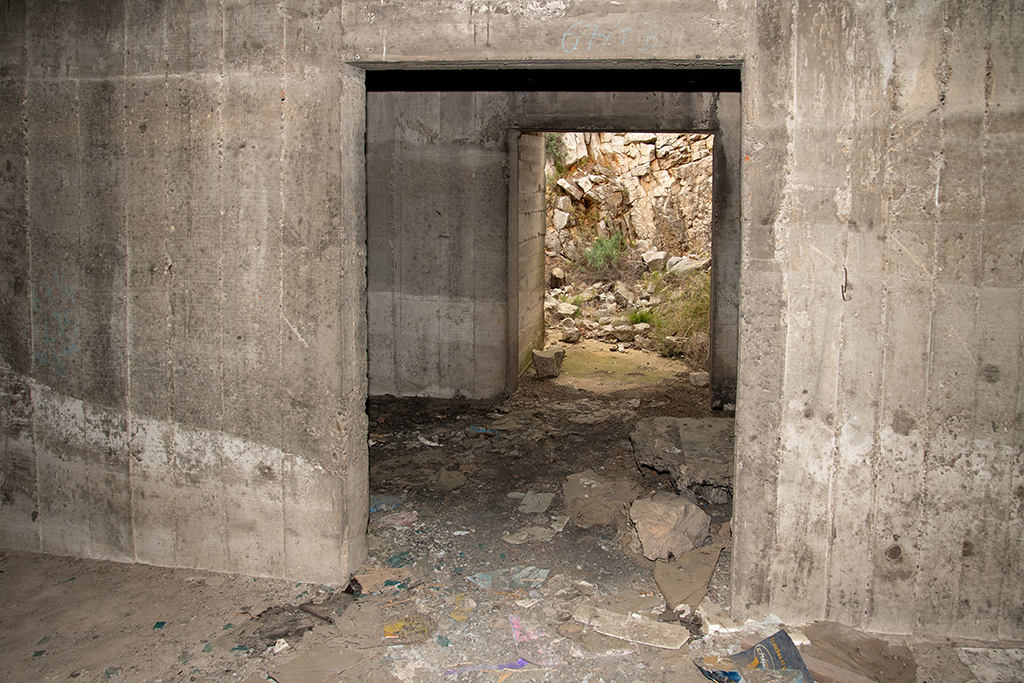 Cuve n°3 de la batterie principale,  intérieur cloisonné de l'abri enterré et porte vers la tranchée d'accès