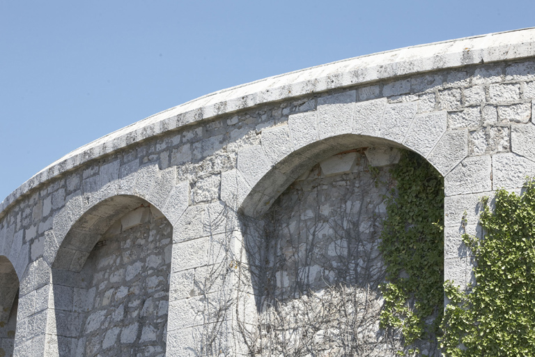 Tour, détail d'arcs de mâchicoulis masquant des modillons de corniche.