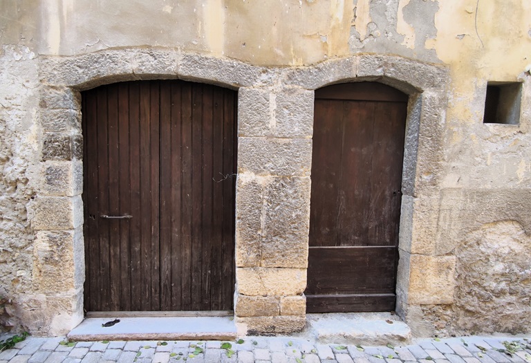 Maison (1833 B 211-212, 2025 B 292-293). Porte charretière et porte piétonne avec encadrements en arc segmentaire et piédroit commun en pierre de taille calcaire. 