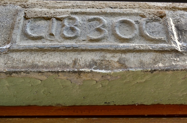 Linteau de porte avec date (1830) sculptée en réserve, ferme en périphérie du bourg.