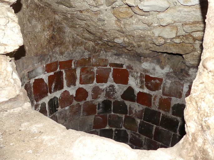 Cellier en étage de soubassement, cuve vinaire circulaire maçonnée et carrelée disposant d'une trémie de remplissage pratiquée à travers la voûte. Ferme des Eymarrons (Ribiers).