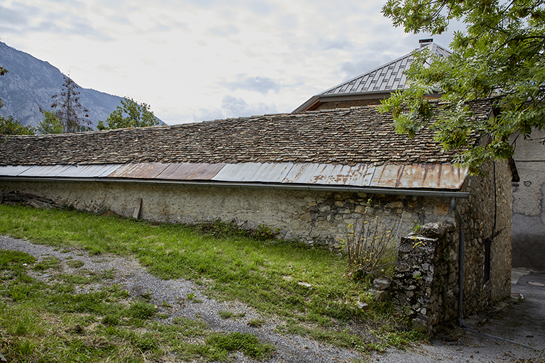Le Village. Entrepôt agricole ancienne fabrique de mallons (tuilerie) au quartier du Riou (parcelle E 60). Le bâtiment est encore partiellement couvert en tuile plate artisanale et tuile écaille.