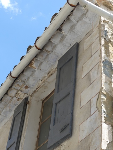 Elévation ouest, décor peint de fausse chaîne harpée et avant-toit constitué de deux rangs de génoise peints en bleu.