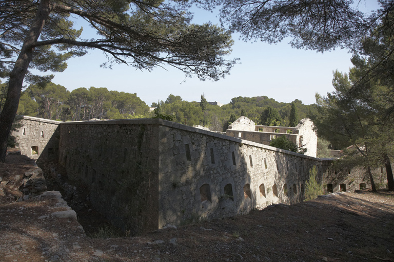 Angle nord-ouest de l'enceinte tenaillée crénelée, front de tête, fossé.