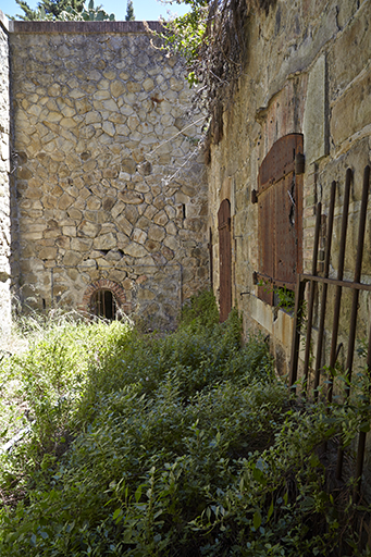 Magasin à poudre enterré, courette encaissée d'accès et façade d'entrée.