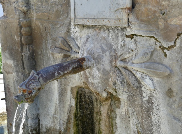 Face nord, mascaron sculpté et canon en fonte à tête de dauphin.