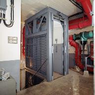 Bloc 1, intérieur : vestibule avec cage d'escalier descendant autour d'un monte-charge, tuyaux de ventilation.