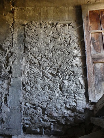 Rez-de-chaussée surélevé, escalier. Mur nord, porte murée avec encadrement décoré d'un tore.