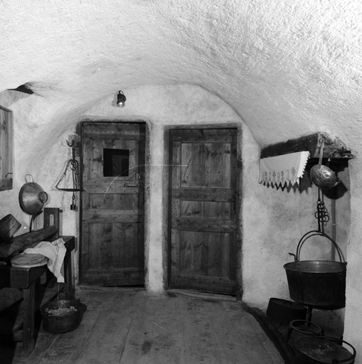 Au fond de la fougagne, de gauche à droite : la presse à tommes, la porte du cellier, la porte de la cave, la cheminée