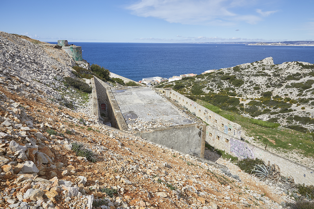 Vue intérieure plongeante de la cour d'entrée encaissée, de son bâtiment et de la courtine gauche du front de gorge avec créneaux