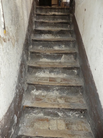 Rez-de-chaussée surélevé, escalier menant à l'étage. Vue de volume.