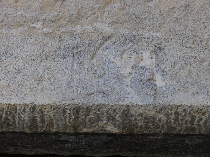 Pignon sud, deuxième niveau. Porte du logis, avec encadrement chanfreiné et date gravée (1651).