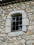 Fenêtre de logis remployant un encadrement en pierre de taille en arc segmentaire. Ferme au quartier de Cabole (Antonaves).