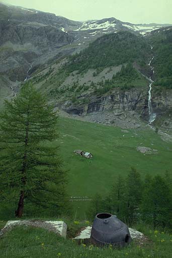 Vallée du torrent d'Abriès vue du point d'appui. Au premier plan, tourelle de mitrailleuse par éléments de gauche. En bas, à droite, emplacements de tentes d'un cantonnement militaire. En arrière, cascade des Sagnes.