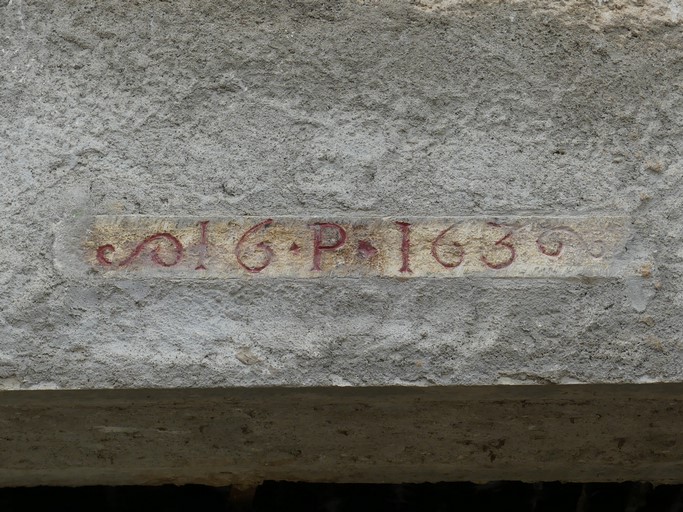 Partie centrale. Pignon est, premier niveau. Elément d'encadrement remployé, portant des initiales et une date gravées et peintes (PI 1663).