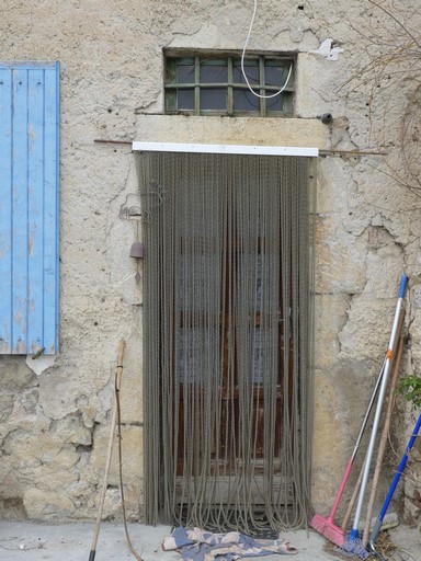 Partie sud, bâtiment oriental. Pignon est, premier niveau. Porte du logis, avec encadrement en pierre de taille intégrant un jour de tympan.