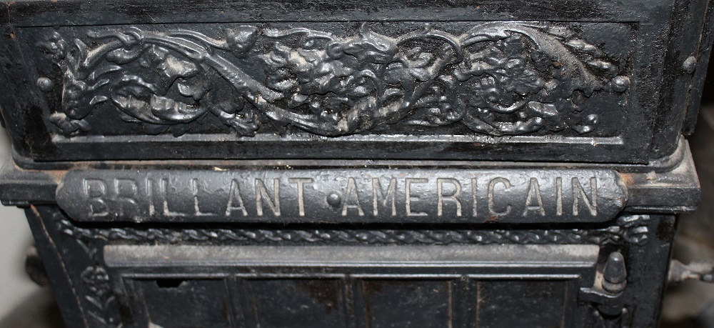 Poêle de chauffage, cage d'escalier commune, détail d'une inscription : BRILLANT AMERICAIN.