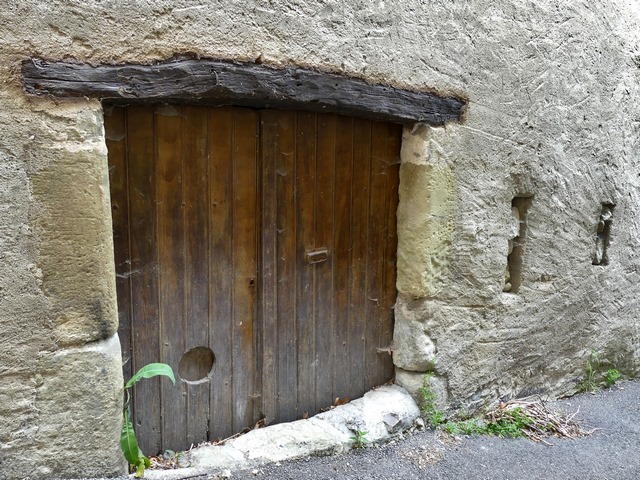 Porte d'étable avec piédroits en pierre de taille de grès et linteau en bois, entrepôt agricole au bourg.