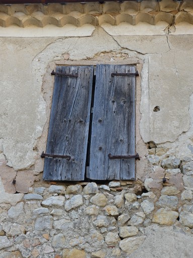 Fenêtre de logis occultée par des contrevents en planches simples. Ferme au quartier du Verger (Ribiers).