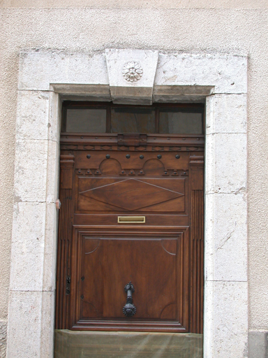 Barrême, parcelle H309. Porte 19e siècle à encadrement en pierre de taille à clef ornée d'un fleuron.