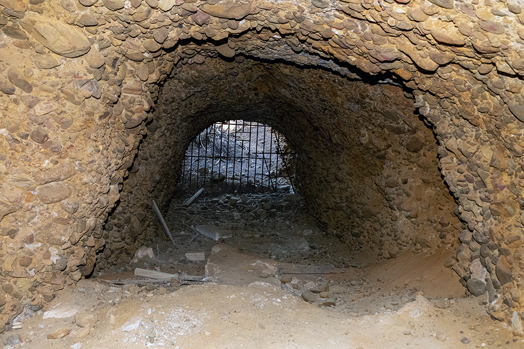 Galerie brute de déroquetage issue avec grille du second souterrain-caverne allemand de 1943 vue de l'intérieur