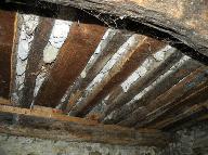 Détail de la mise en oeuvre du plafond d'une étable dans une maison à Rougon : solives et solivettes avec remplissage de mortier et gravas.