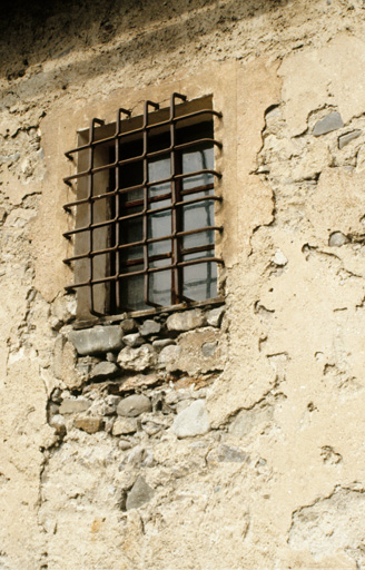 Façade est. Fenêtre de la chambre ménagère. Noter l'encadrement peint et la grille saillante.