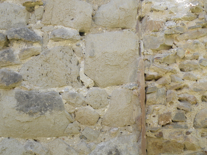 Drogou. Détail d'une élévation en gros blocs de grès, au contact du remplissage en maçonnerie d'une porte murée.