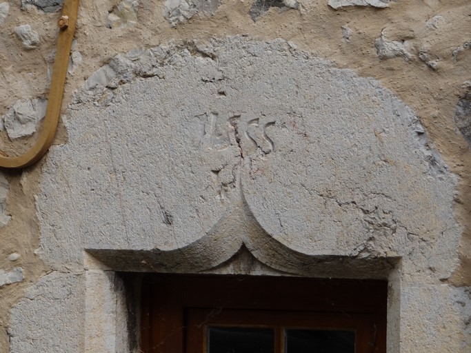 Porte de logis avec encadrement chanfreiné et linteau à accolade portant la date de 1555. Maison située rue du Château au bourg de Ribiers (parcelle 1998 E2 693).