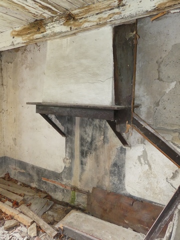 Rez-de-chaussée surélevé, logis. Mur ouest, cheminée.